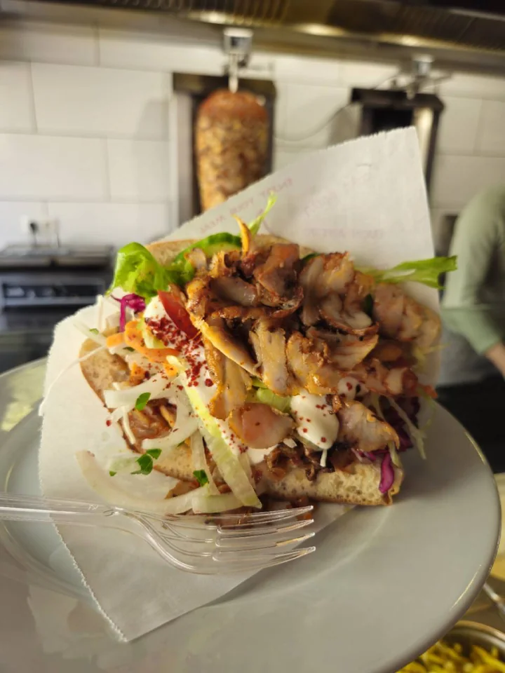 Döner mit Fleisch, Salat und Sauce auf einem Teller
